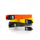 Stack of kids BJJ belts in orange, yellow, gray, and white with Rubber Bones labels.