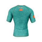 Back view of teal green short-sleeve rash guard with orange stitching and Joe Tamponi x Rubber Bones logo at the top.
