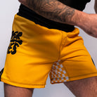 Volt Ranger BJJ Shorts (Movement Shot) – A male model wearing the yellow Volt Ranger BJJ shorts in a training stance, highlighting the flexible fit and stretch panel design.