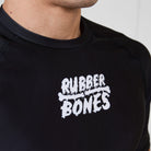 Close-up of white Rubber Bones logo printed on the chest of the Men’s Ash BJJ Rash Guard.
