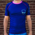 On-body front view of Invasion Short Sleeve Rash Guard with bold alien-inspired artwork.