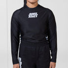Model wearing the Women’s Long Sleeve Ash BJJ Rash Guard with black base, white Rubber Bones logo, and subtle marble side panels.