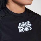 Close-up of white Rubber Bones logo printed on the chest of the Men’s Long Sleeve Ash BJJ Rash Guard.