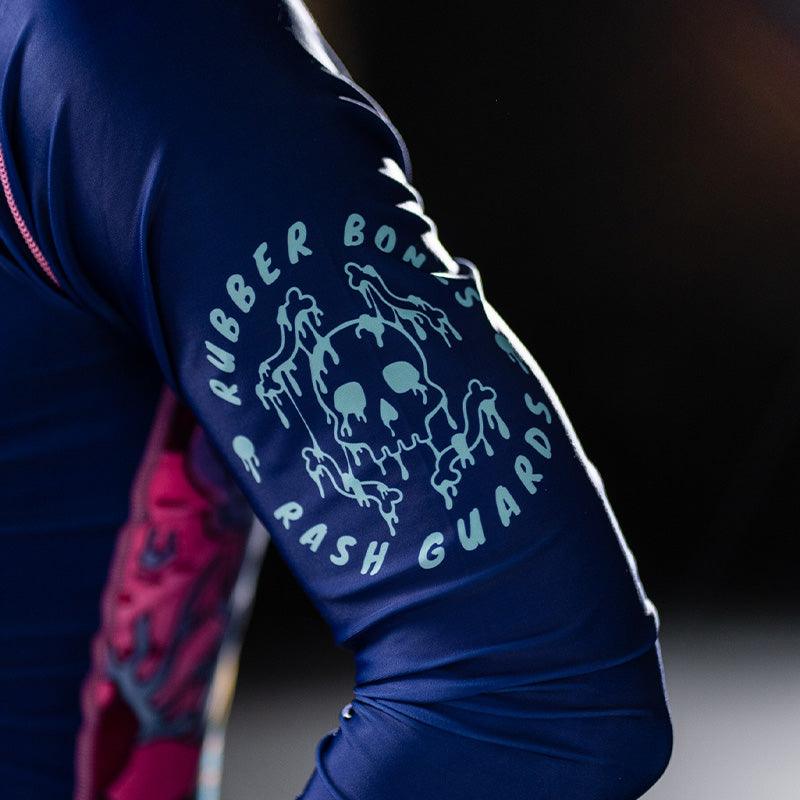 On-body close-up of Invasion Long Sleeve Rash Guard sleeve featuring Rubber Bones logo graphic.