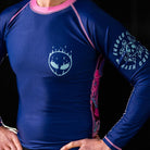 On-body close-up of Invasion Long Sleeve Rash Guard highlighting alien head graphic on the right chest.