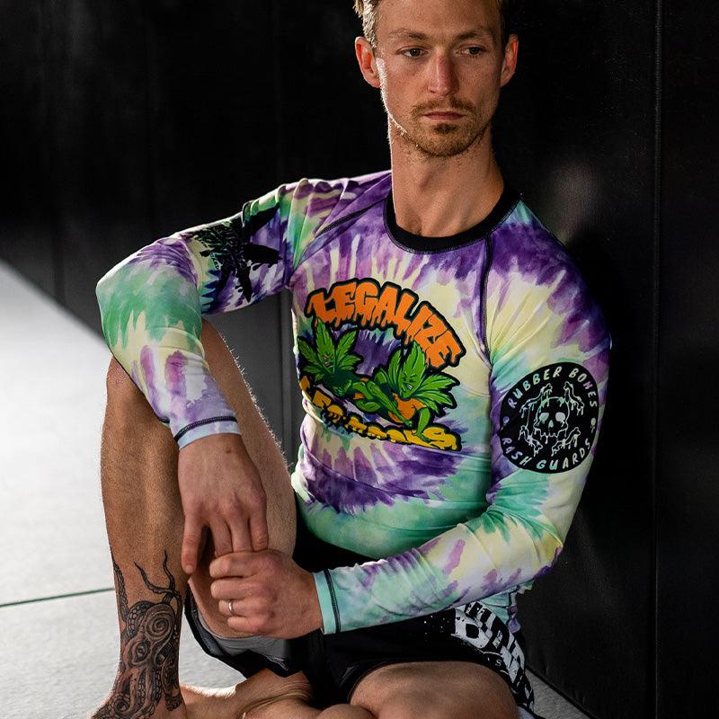 On-body seated 3/4 view of Legalize Leg Locks Long Sleeve Rash Guard with vibrant colors and statement design.