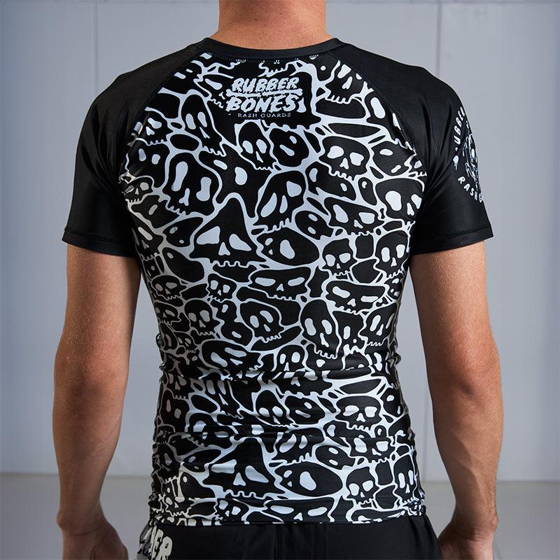 On-body back view of Ranked Rash Guard - Black highlighting monochromatic skull web artwork.