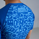 On-body back view of Ranked Rash Guard - Blue highlighting sleek monochromatic skull web design.