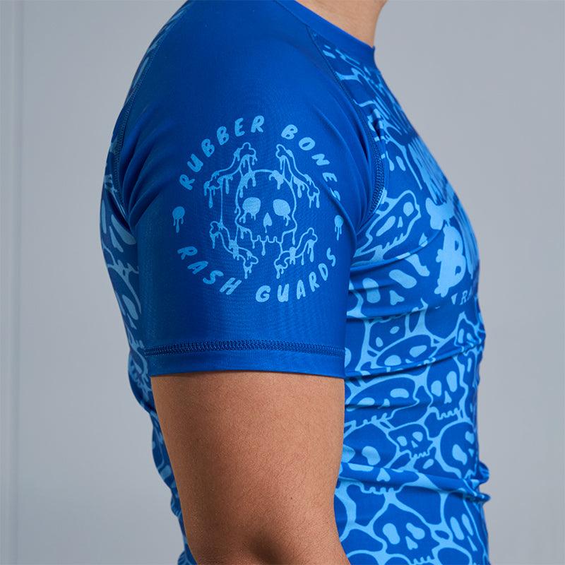 On-body side view of Ranked Rash Guard - Blue sleeve showing Rubber Bones logo on solid blue sleeve.