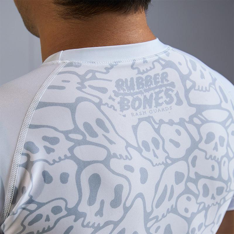 On-body 3/4 view close-up of back of Ranked Rash Guard - White highlighting Rubber Bones logo and skull web design.