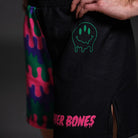 Close-up of the Bubble Gum Grappling Shorts with a dripping green smiley face and pink Rubber Bones logo.
