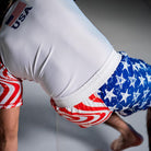 On-body back view of Independence Grappling Shorts, American flag-inspired design, with athlete on the ground.