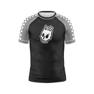 Shadow Ranger Kids BJJ Rash Guard (Front View) – Short-sleeve kids’ BJJ rash guard with a black body, gray raglan sleeves featuring a white checkerboard pattern, and a white skull logo on the chest.