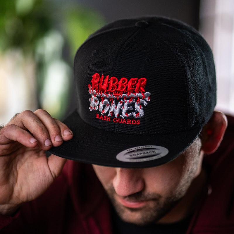 On-body front view of OG 2.0 Snapback Hat featuring classic structured fit and bold Rubber Bones design.