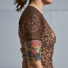 On-body side sleeve view of Women's Brown Ranked Rash Guard featuring Rubber Bones logo.
