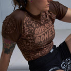 On-body 3/4 front view of Women's Brown Ranked Rash Guard showcasing the fit and skull web pattern.