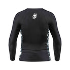 Back view of the Kids Long Sleeve Ash BJJ Rash Guard showing black design with white melting skull Rubber Bones logo near neckline and marble side accents.
