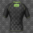 Back view of the Bad Bone Rash Guard featuring a black and grey skull pattern and green accents.