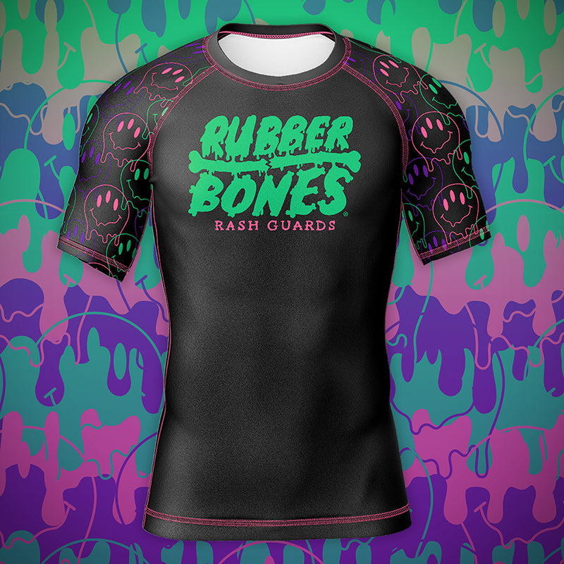 Mock-up of the Bubble Gum Rash Guard with vibrant black, pink, green, and purple design featuring dripping alien smiley faces.