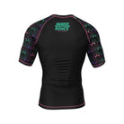 Black short-sleeve BJJ rash guard with neon green 'Rubber Bones Rash Guards' branding on the upper back. Sleeves feature a repeating pattern of melting smiley faces in green, pink, and purple, outlined in neon.