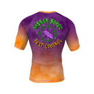 A vibrant BJJ rash guard featuring a purple-to-orange gradient background. The back showcases a large green crosshair graphic with a cockroach in the center, accompanied by the text "Rubber Bones Pest Control" in a graffiti-style font.