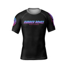 Front view of the Cotton Candy BJJ rash guard by Rubber Bones. A minimalist black rash guard with the Rubber Bones logo in a cotton candy-inspired gradient of pink, purple, and blue across the chest. Subtle branding on the sleeves adds extra detail.