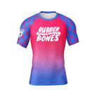 Front flat lay of the Rubber Bones Toxic Berry men’s short sleeve BJJ rash guard featuring pink and blue gradient body with skull print sleeves.