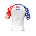 A short-sleeve BJJ rash guard with a white base, featuring a bold USA flag-inspired design. The left sleeve has red and white wavy stripes, while the right sleeve has a distressed blue background with white stars. "USA" and an American flag are printed on the upper back.