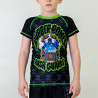 Bad Bones Kids BJJ Rash Guard, front view, featuring a St. Bernard dog holding a leg in its mouth, with a black and grey skull pattern and green stitching.