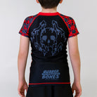 Black OG 2.0 Kids BJJ Rash Guard, back view, showcasing a Drip Skull design with the Rubber Bones logo at the bottom, and red and grey skull pattern sleeves.