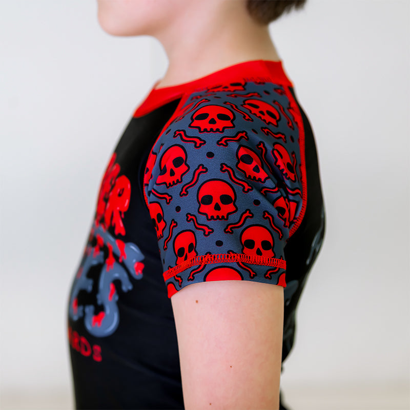 Close-up of the left sleeve of the OG 2.0 Kids BJJ Rash Guard, featuring a grey sleeve with red skull pattern.