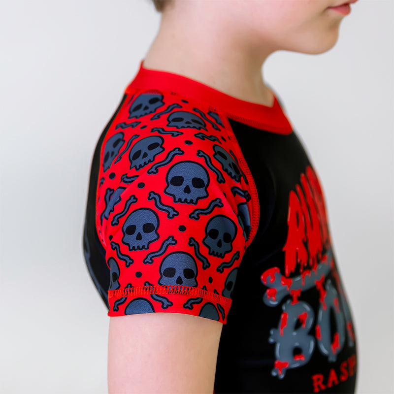 Close-up of the right sleeve of the OG 2.0 Kids BJJ Rash Guard, featuring a red sleeve with grey skull pattern.