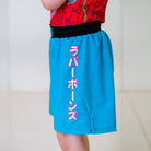 Light blue Hannya Youth Shorts, left side view, highlighting Japanese lettering spelling "Rubber Bones."