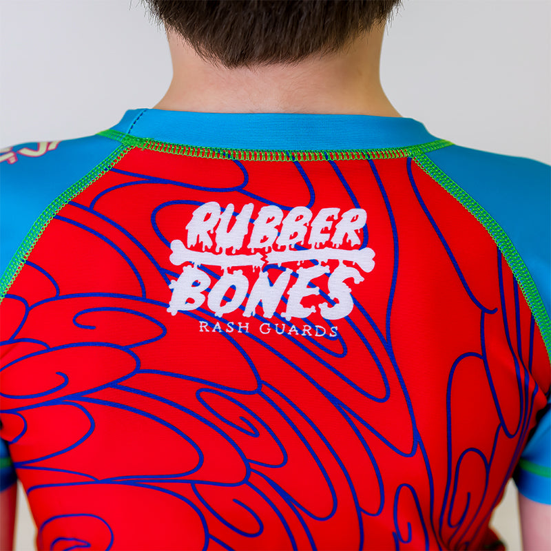 Close-up of the back of the Kids Hannya BJJ Rash Guard, featuring the white Rubber Bones logo at the nape of the neck with a Japanese-inspired spiral pattern.