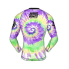 Long-sleeve BJJ rash guard with a vibrant purple, green, and yellow tie-dye spiral pattern. Features the 'Rubber Bones Rash Guards' logo in black on the upper back.