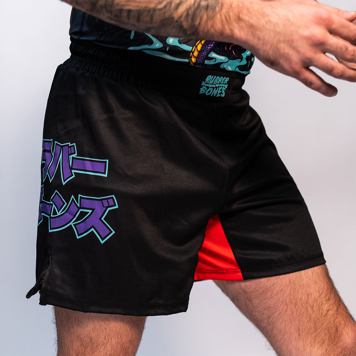 Rubber Bones Tora Oni BJJ Shorts – Black no-gi fight shorts with Japanese lettering on the side and a red stretch gusset for mobility.