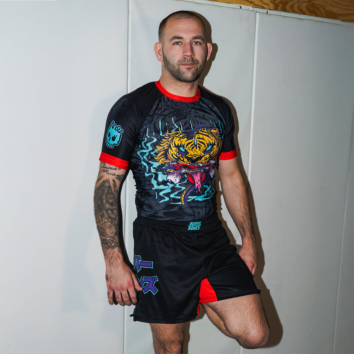 Athlete wearing the Rubber Bones Tora Oni rash guard and BJJ shorts – Black no-gi set featuring a tiger-demon design, Japanese lettering, and red accents.