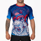 Men's Yeti Games short sleeve rash guard front view with skeleton skier choking Yeti artwork in patriotic red, white, and blue, USA flag patch on sleeve, compression fit.