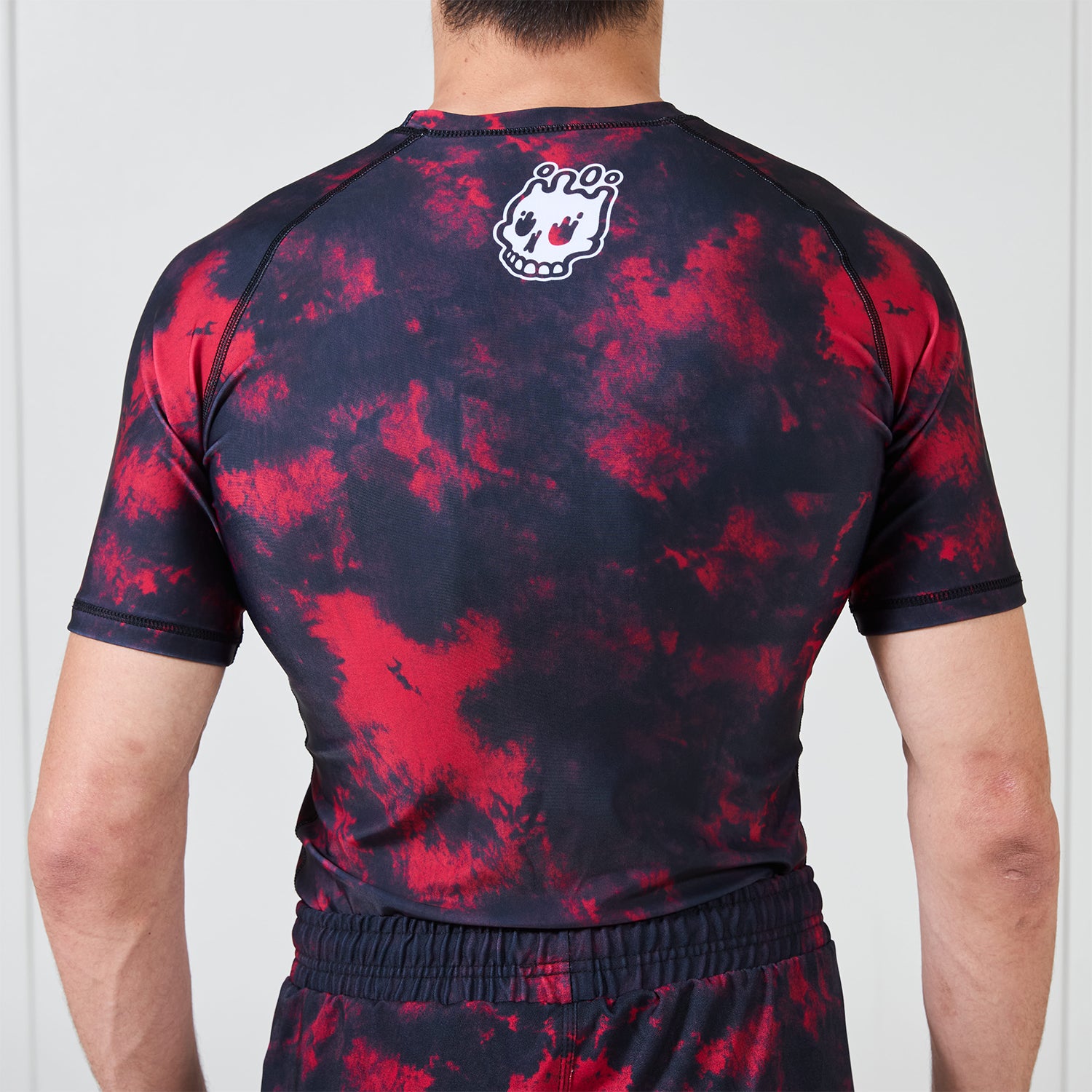 Back view of the Ember Men’s BJJ Rash Guard showing the melting skull Rubber Bones logo at the upper back.