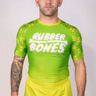 Front view of the Rubber Bones Poison Apple men’s BJJ rash guard with bright green body and skull print sleeves from the Deadly Harvest Collection.