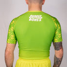 Back view of the Poison Apple men’s no gi rash guard featuring green fade body and repeating skull artwork sleeves.