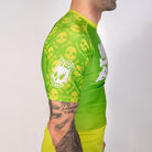 Side profile of the Poison Apple men’s grappling rash guard showing lime green skull print sleeve artwork and compression fit design.