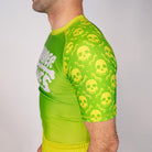 Close-up detail of the Poison Apple no gi BJJ rash guard sleeve featuring neon skull graphics and fully sublimated artwork.