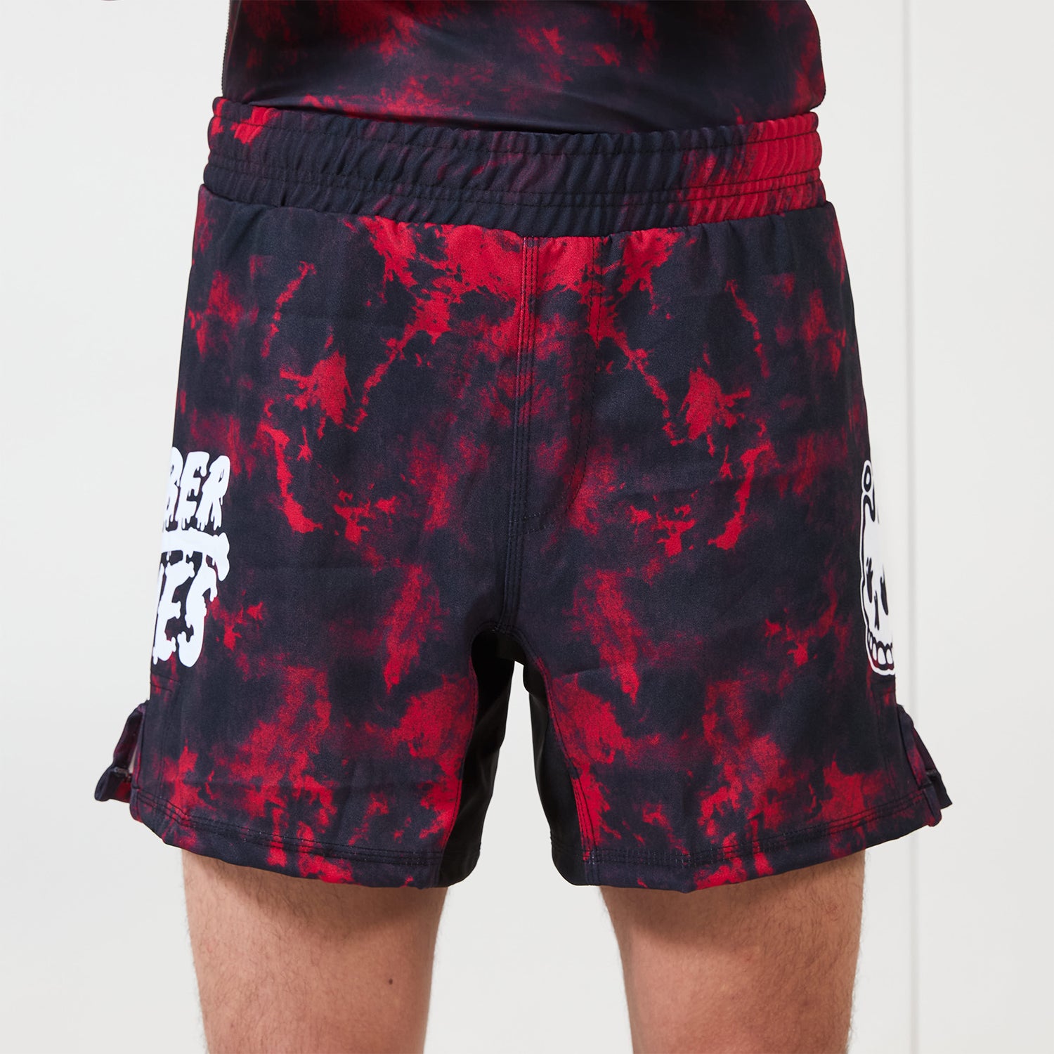 Men’s Embers BJJ Shorts – red and black marble pattern with white Rubber Bones logo on left leg, front view on plain background.