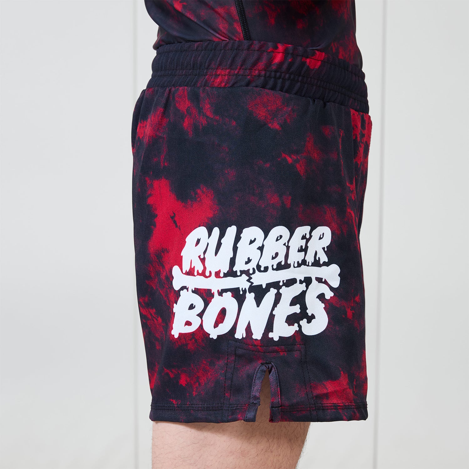 Side view of Men’s Embers BJJ Shorts showing red and black marble design and large white Rubber Bones logo.