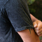 Detail of sleeve stitching and mineral wash texture on the Rubber Bones Guillotine T-shirt.