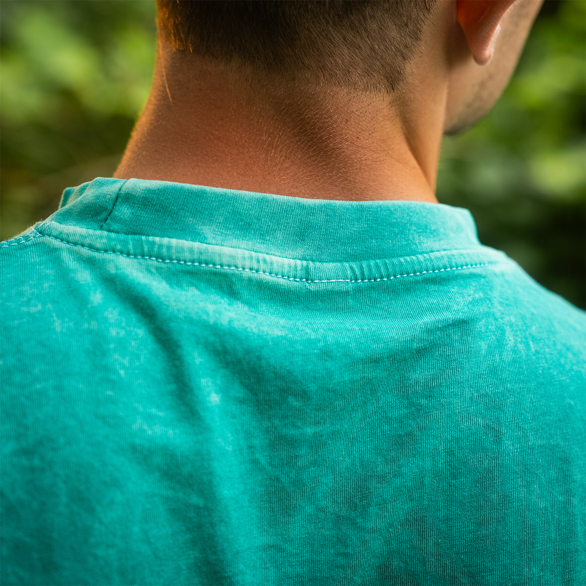 Back collar detail of the teal mineral wash t-shirt, showing stitching and worn-in texture. Premium Rubber Bones limited edition shirt.
