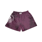 Front View. Maroon no-gi shorts with subtle black tie-dye accents, high-cut sides for mobility, and an elastic waistband with the Rubber Bones logo. Features a bold skeleton illustration and 'Natural Grappler' text on the left leg.