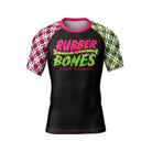 Black women’s short-sleeve BJJ rash guard with 'Rubber Bones Rash Guards' in neon pink and green dripping font on the chest. The sleeves feature bold green and pink skull patterns, complemented by pink collar trim.