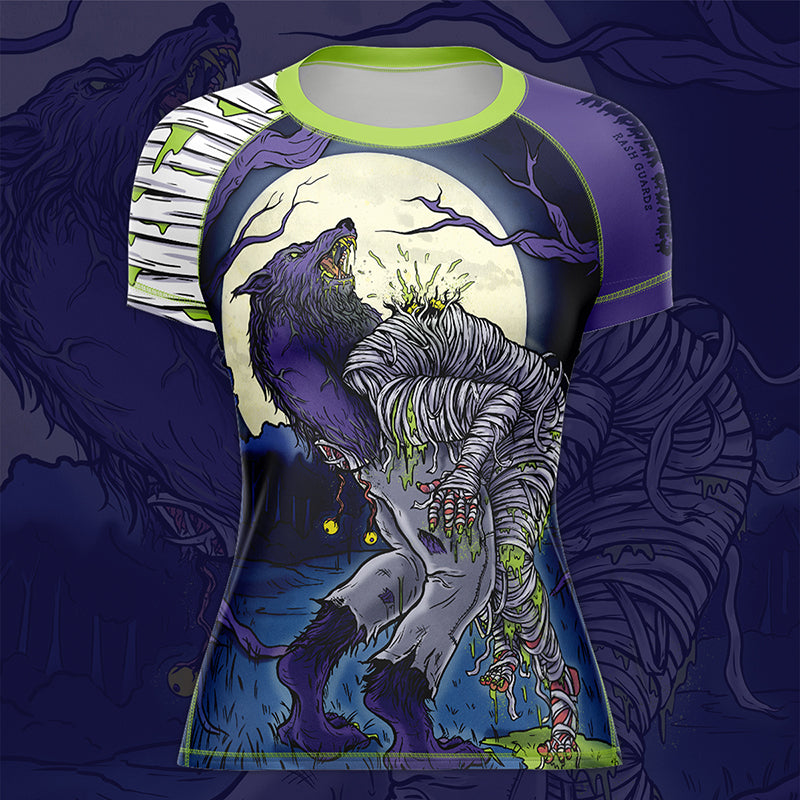 Women's Full Moon BJJ Rash Guard mock-up, front view, featuring a werewolf guillotining a mummy in bold blues, purples, and green accents.